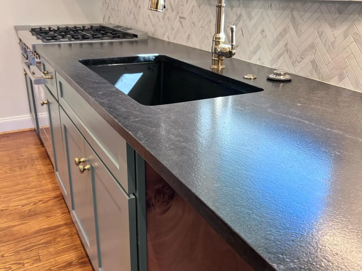 White herringbone tile backsplash above a dark stone countertop