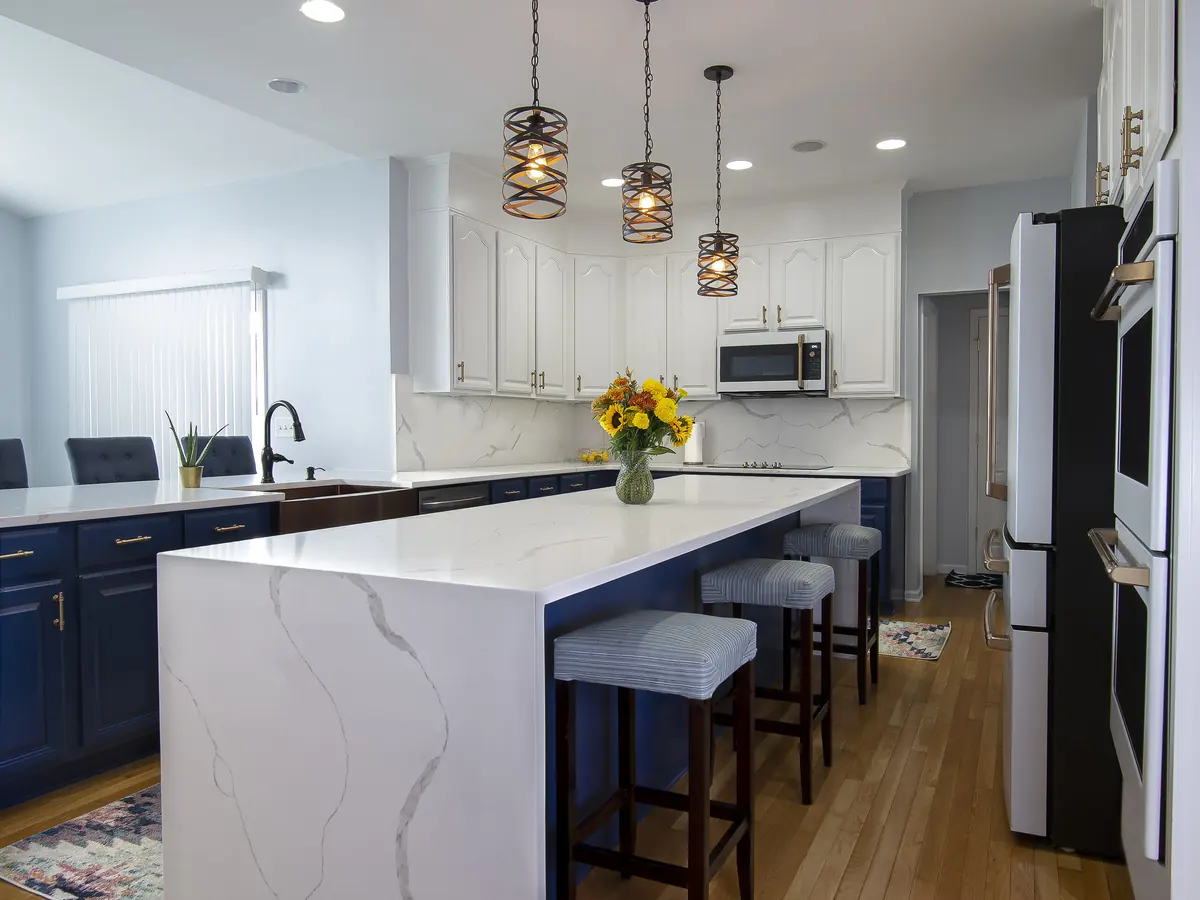 Remodeled kitchen with a waterfall island and stone countertops