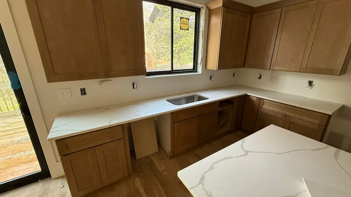 New wood cabinets and white quartz countertops in a kitchen