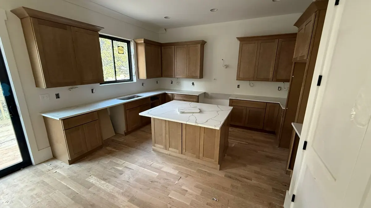 New wood kitchen cabinets with white quartz countertops installed after the cabinets were set