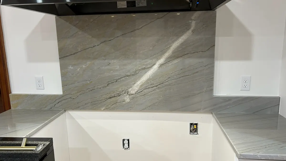 Full-height stone backsplash behind a range