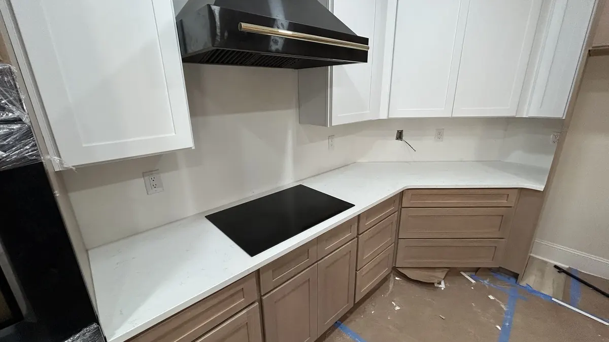 White quartz countertop beside an induction cooktop