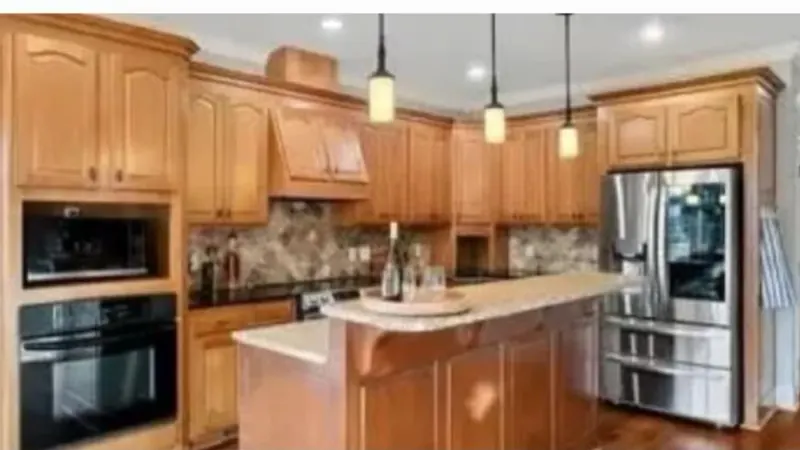 Dated kitchen with honey oak cabinets before a remodel
