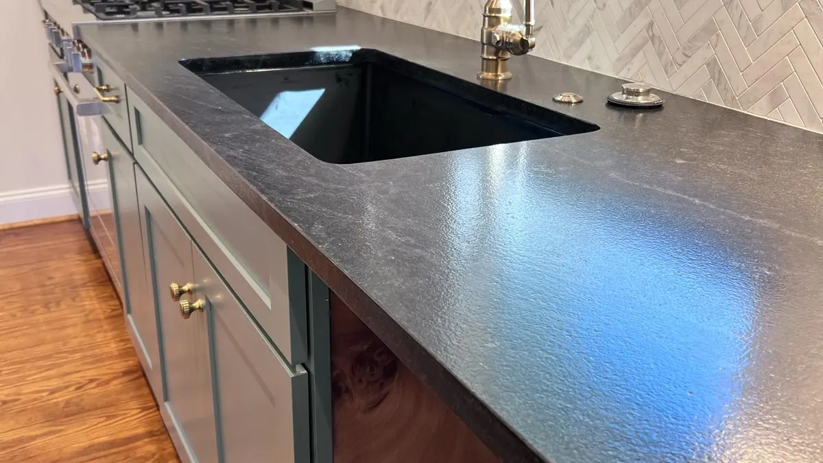 Dark leathered stone countertop along a kitchen sink