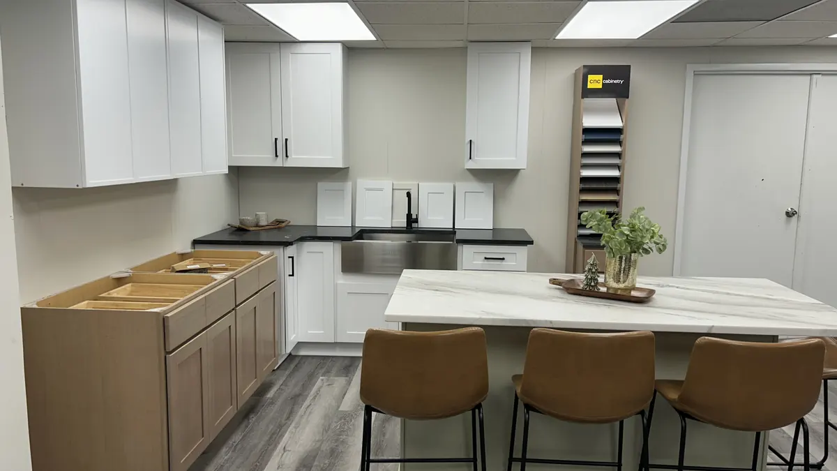 Showroom kitchen with cabinets and a stone countertop island