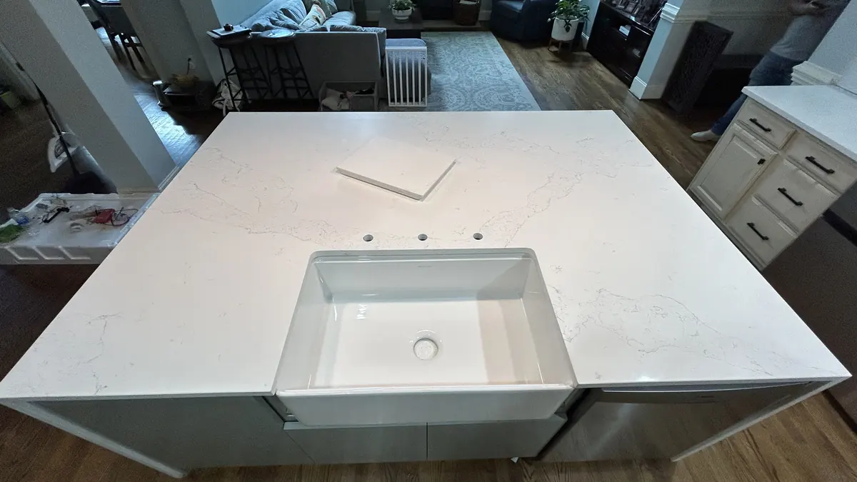Farmhouse sink set in a white quartz island