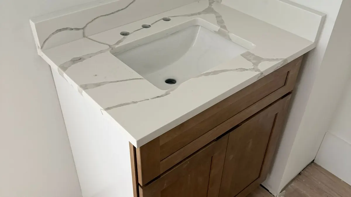 Wood vanity cabinet with a new white quartz top