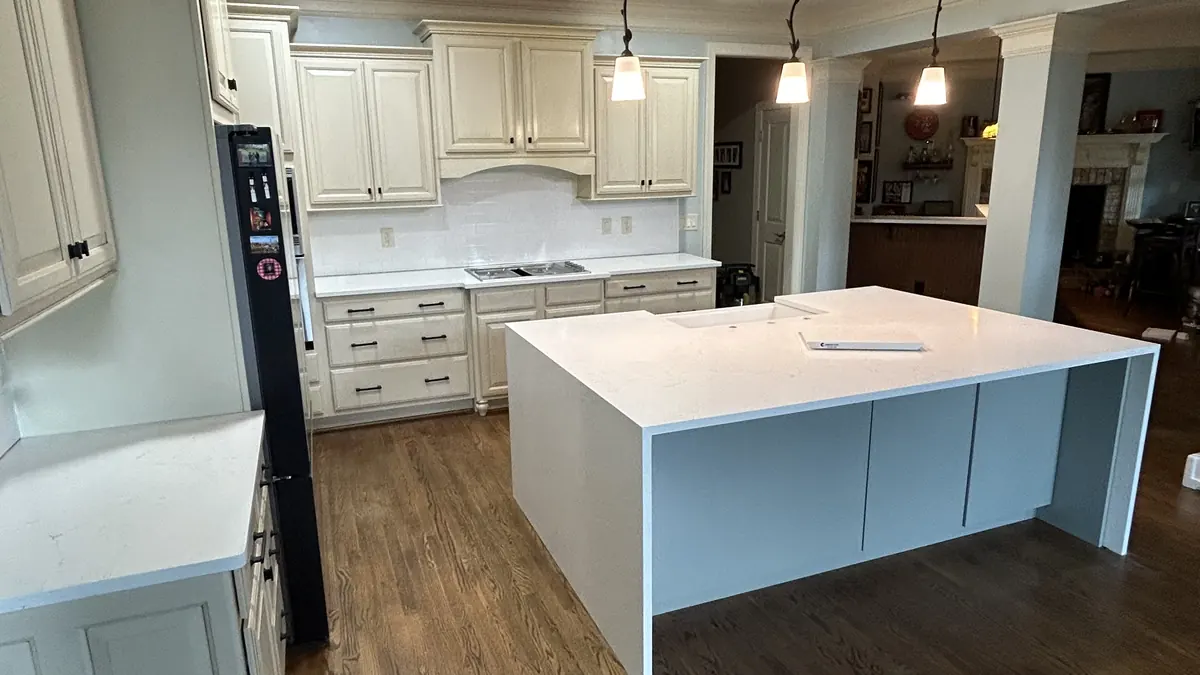 White quartz waterfall island in an open kitchen