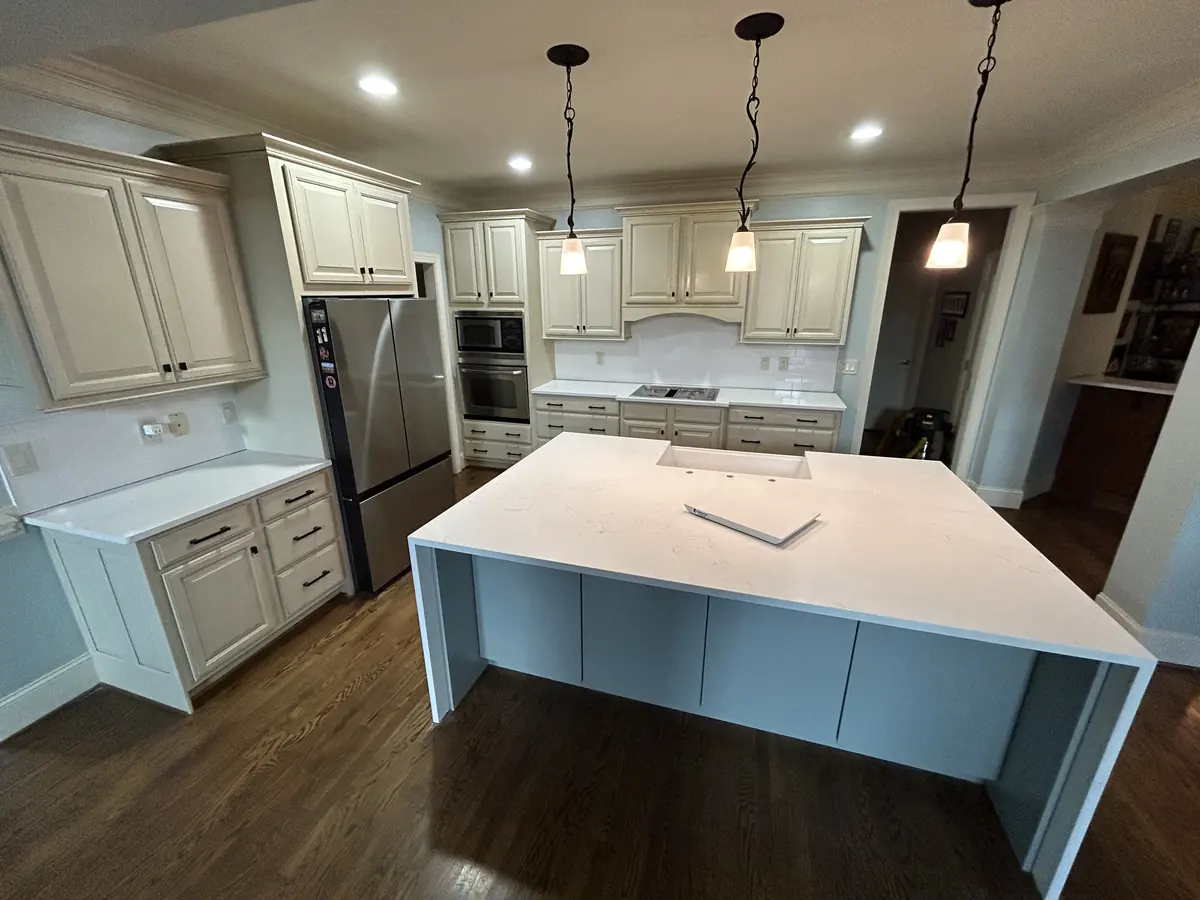 Large white quartz kitchen island top with pendant lights above