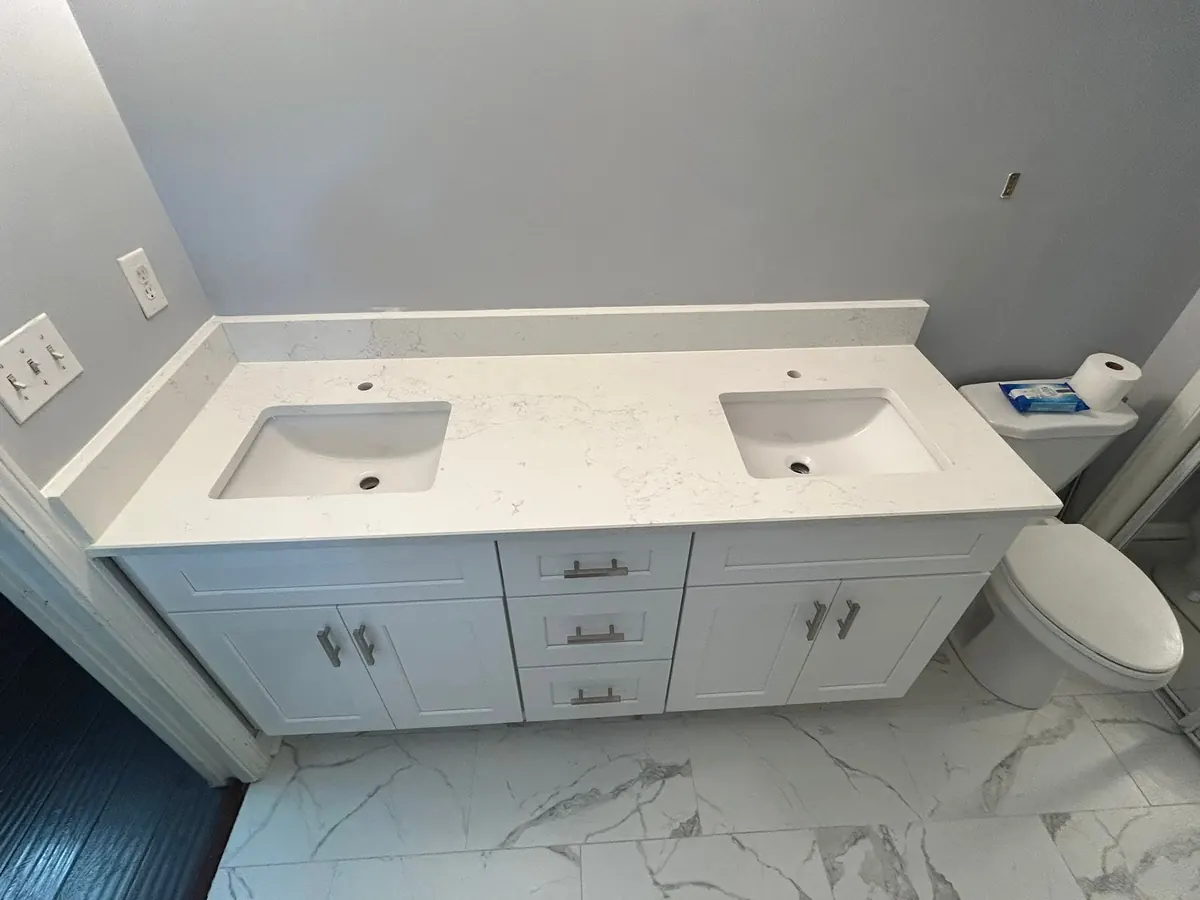 Double vanity with a white marble-look top and two undermount sinks