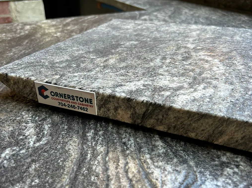 Close-up of a granite countertop edge with a Cornerstone label