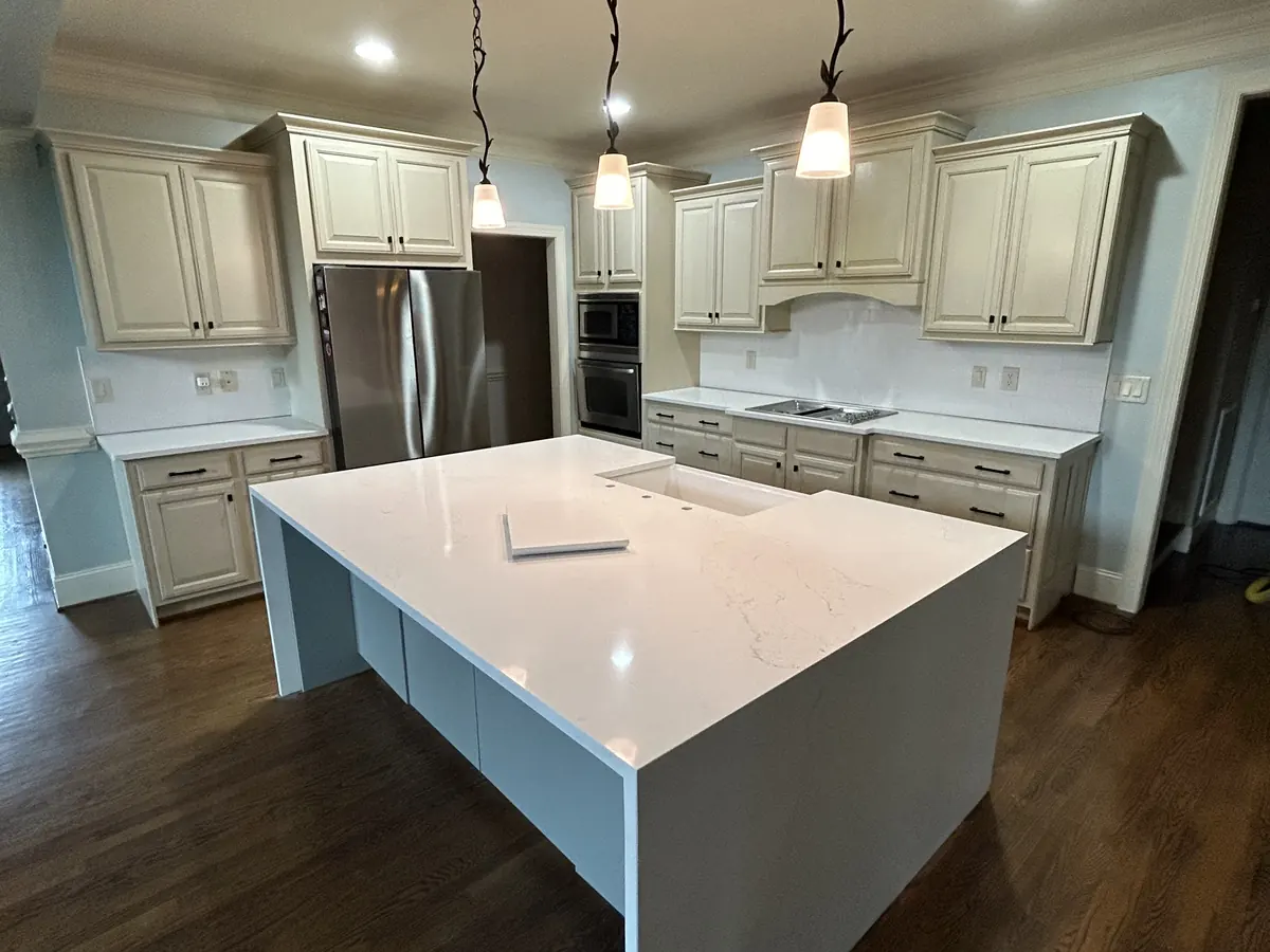 Large white waterfall island in an open kitchen