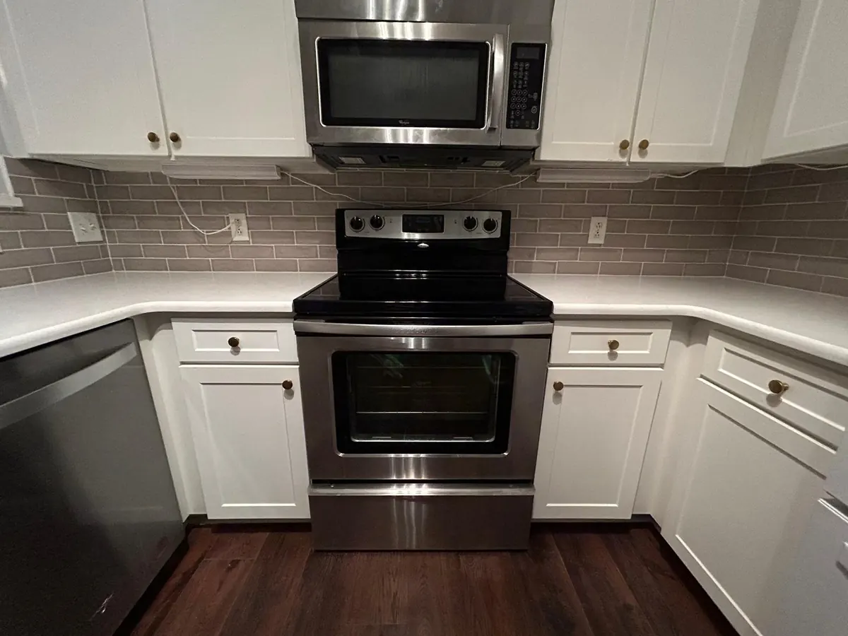 Kitchen backsplash above a white countertop and a stainless steel range