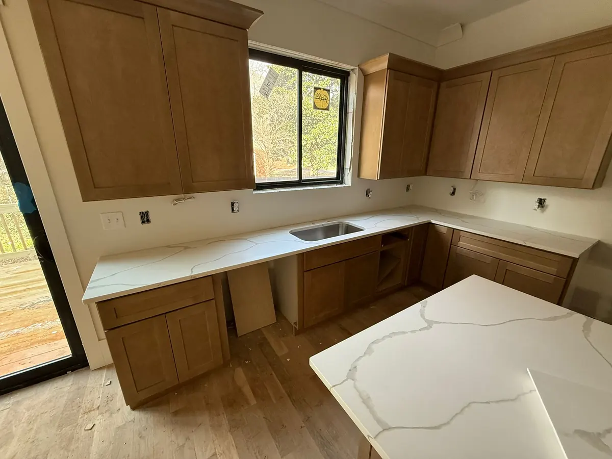 New wood cabinets with white quartz countertops in a new kitchen