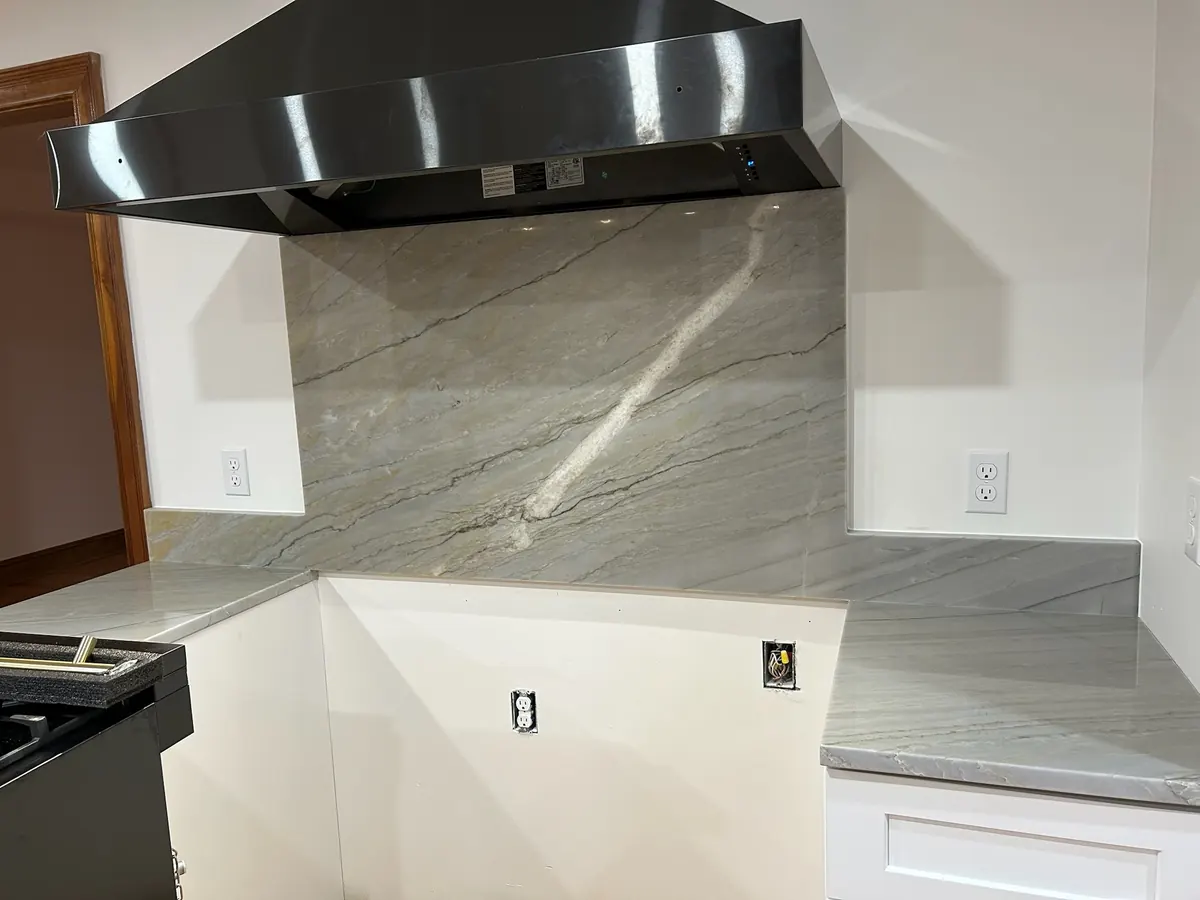 Kitchen wall finished with a full-height stone backsplash that matches the countertop