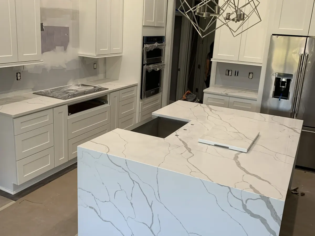 White quartz waterfall island with bold gray veins