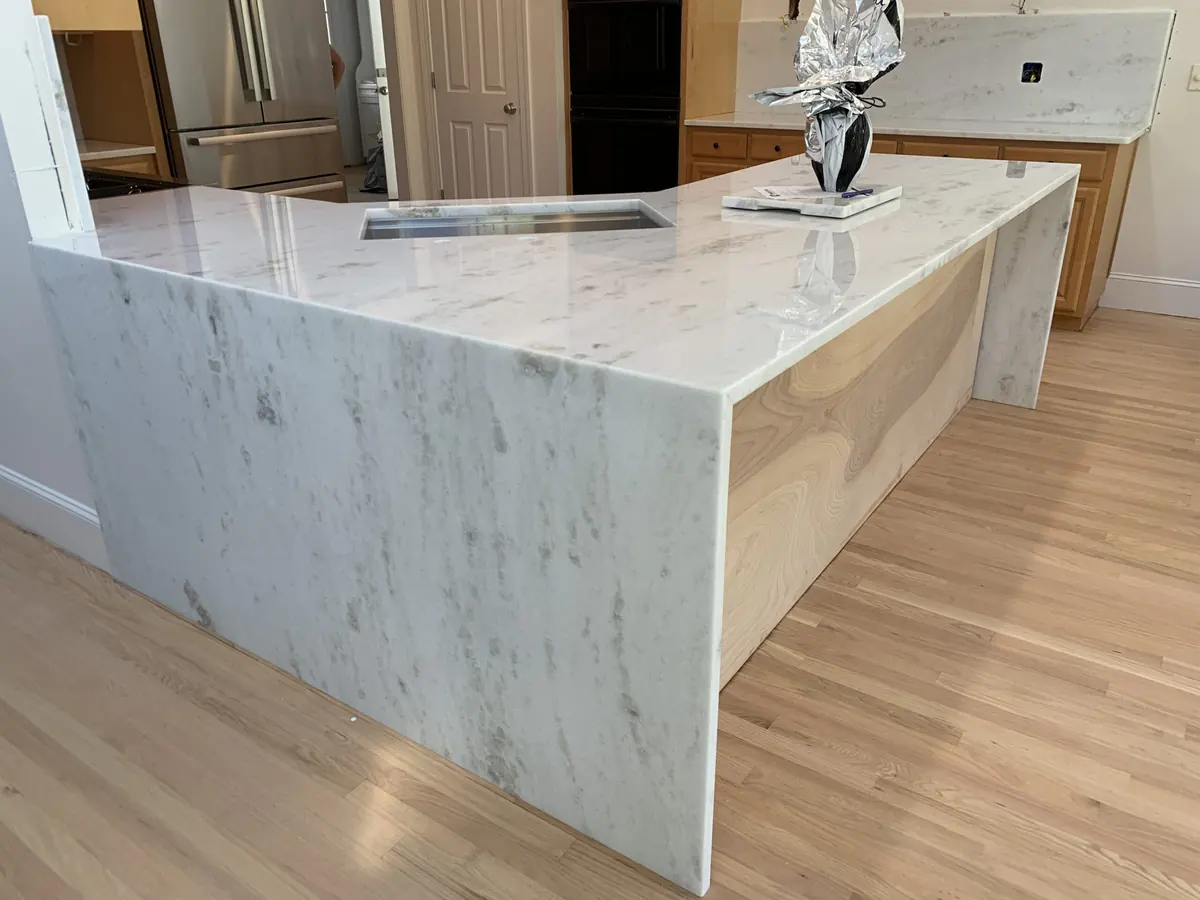 Warm white natural stone waterfall island with soft veins